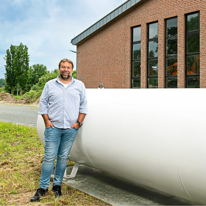 Dipl.-Ing. Stephan Giesen, Geschäftsführer Kreis Kleve Bauverwaltungs-GmbH (KKB), vor einem oberirdischen Flüssiggastank, im Hintergrund Fahrzeughalle.